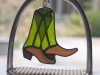 Stained glass pair of riding boots hanging in a stirrup