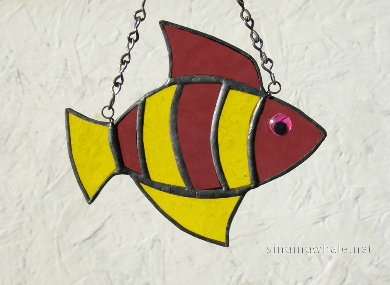 Made of hammered yellow and rough roll cranberry glass. Eye is a pink wiggle eye securely glued on. Finished in a pewter patina. Measures 4 3/4 " wide by 4" tall. Fish in this pattern are $15 each.